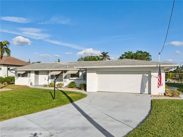 Ranch-style house featuring a garage and a front yard
