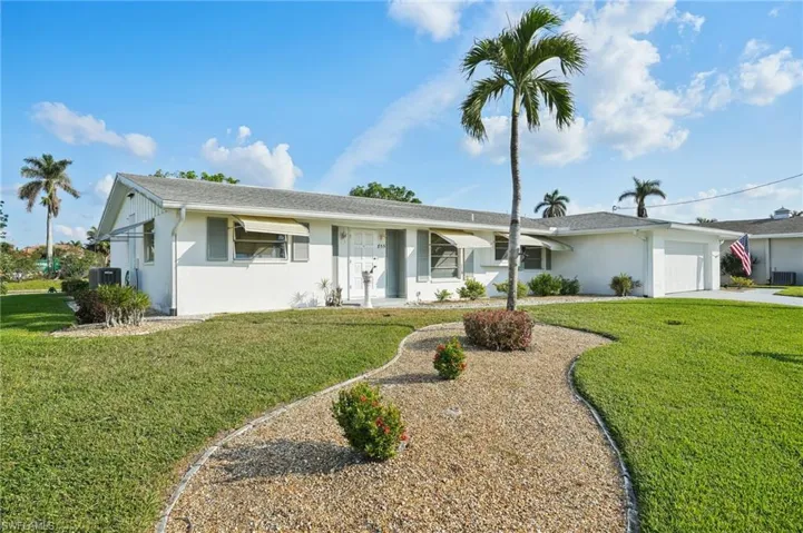 Single story home with a front yard and a garage
