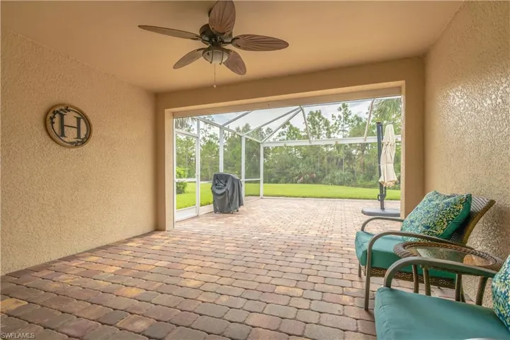 View of patio / terrace featuring glass enclosure and ceiling fan