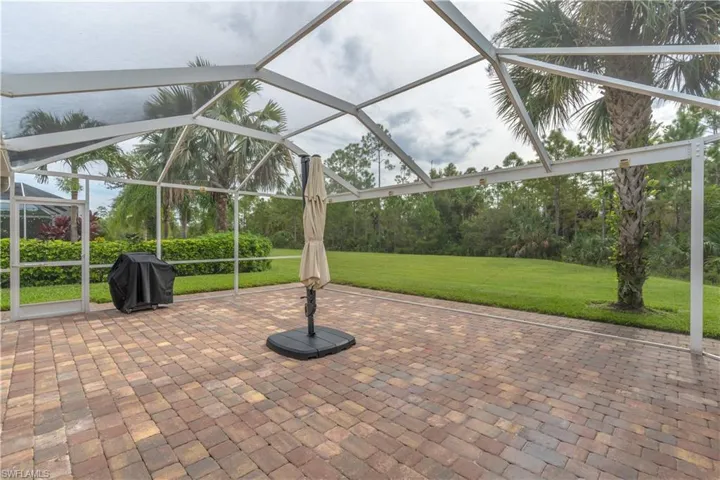 View of patio with glass enclosure and area for grilling