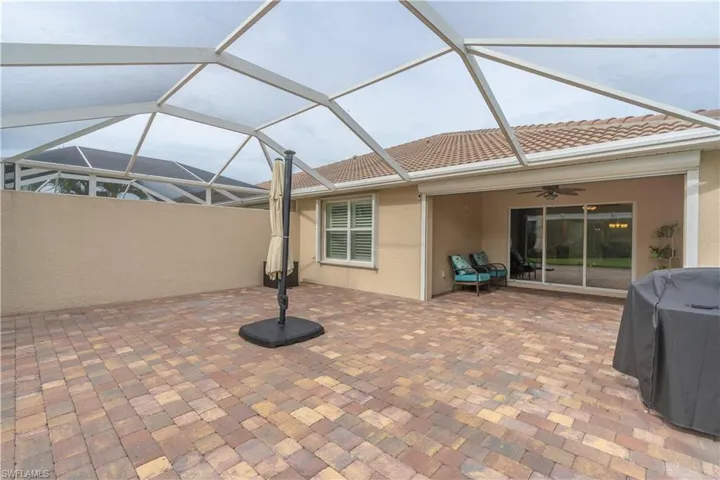View of patio with ceiling fan, area for grilling, and a lanai