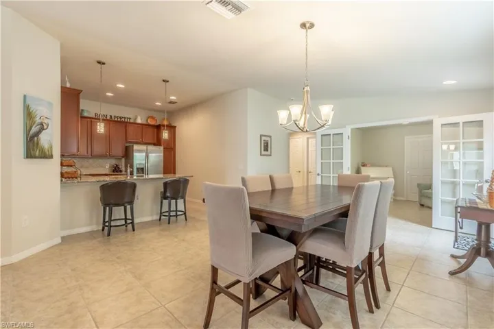 Tiled dining space with an inviting chandelier and lofted ceiling