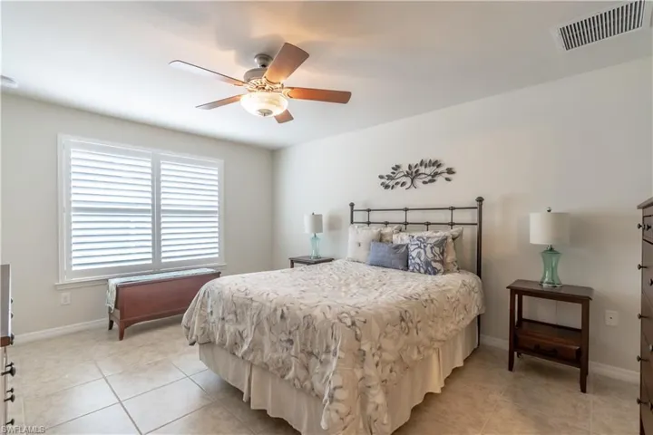Bedroom with ceiling fan and light tile patterned flooring
