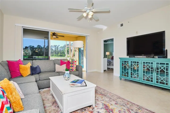 Living room featuring light tile patterned floors and a ceiling fan