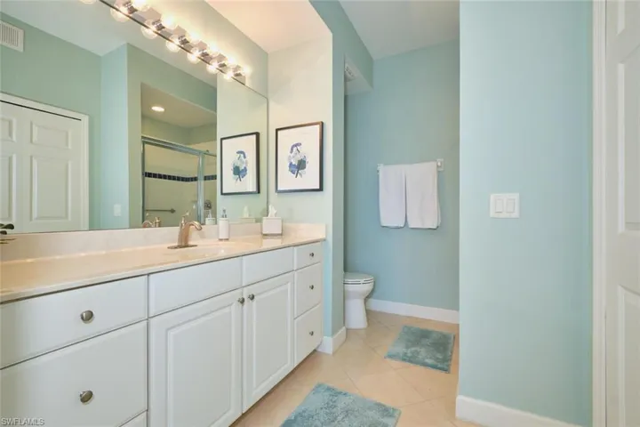 Bathroom featuring a stall shower, vanity, and light tile patterned floors