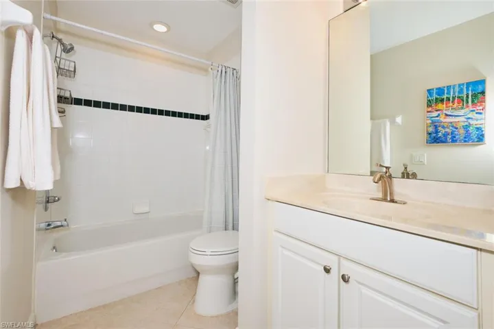 Bathroom featuring vanity, shower / bath combo, light tile patterned floors, and recessed lighting