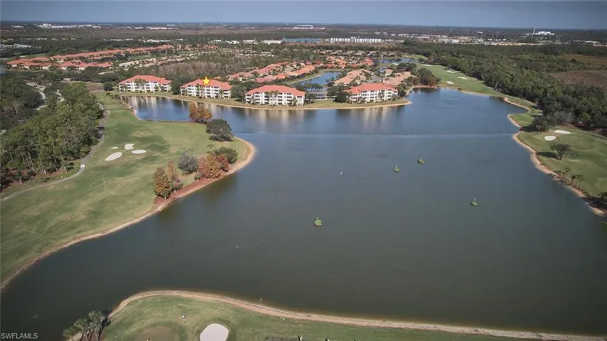 Aerial view of property's location featuring a golf club and a nearby body of water