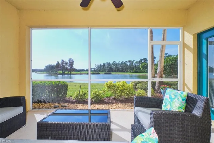 Sunroom / solarium with a water view and view of scattered trees