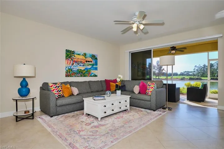 Living area featuring ceiling fan, a water view, and tile patterned floors