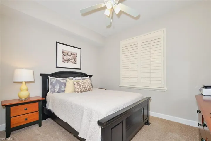 Bedroom with a ceiling fan and light carpet
