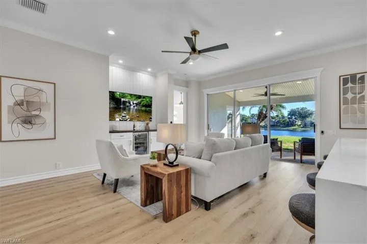 Living area featuring light wood-type flooring, recessed lighting, ceiling fan, and crown molding