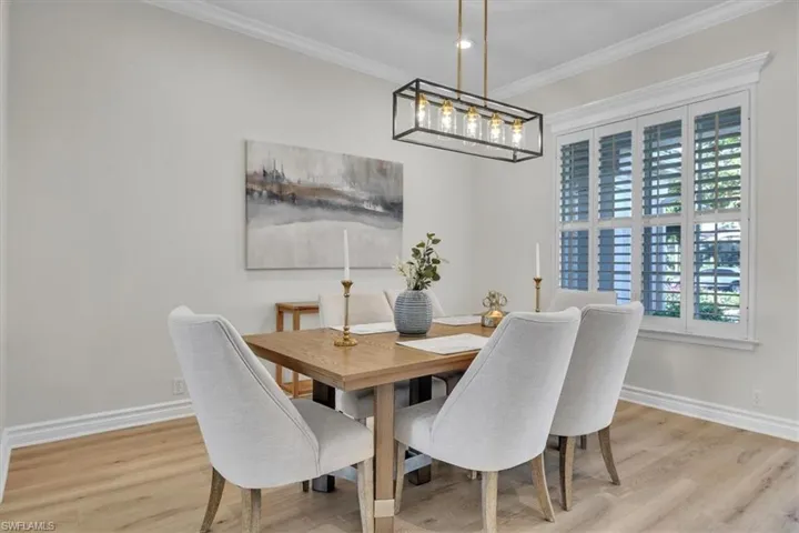 Dining area with crown molding and wood finished floors
