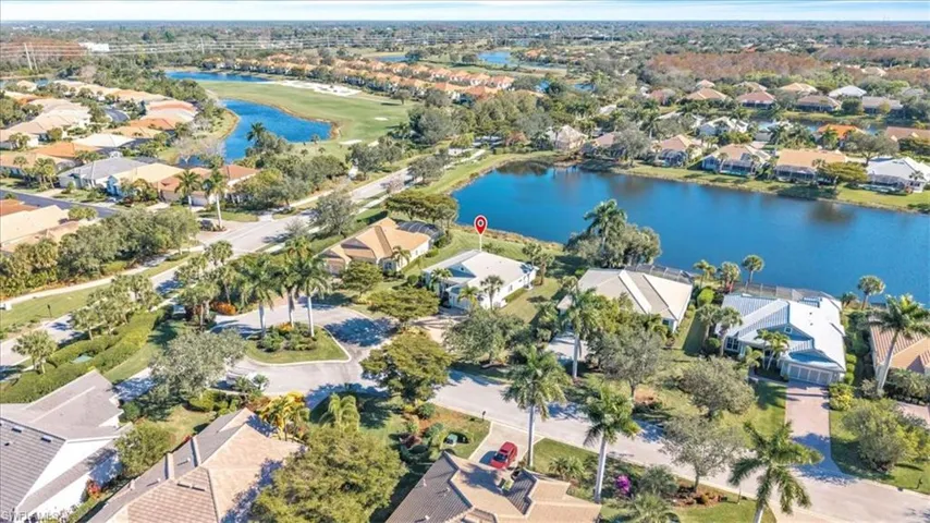 Aerial view of property and surrounding area featuring nearby suburban area and a large body of water