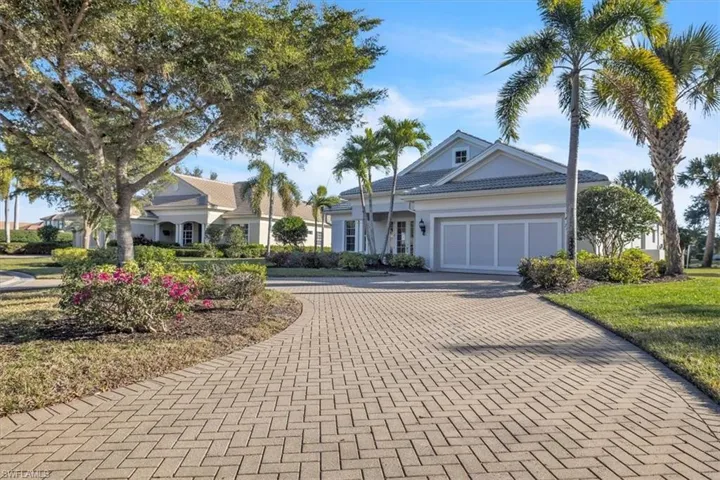 View of front of house with decorative driveway, an attached garage, and stucco siding