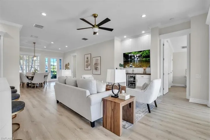 Living area with light wood-style floors, recessed lighting, crown molding, and ceiling fan