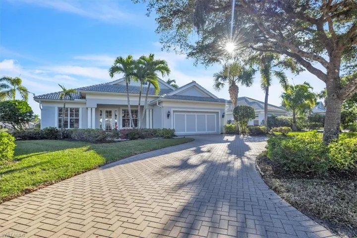 Ranch-style house featuring decorative driveway, stucco siding, an attached garage, a front yard, and covered porch