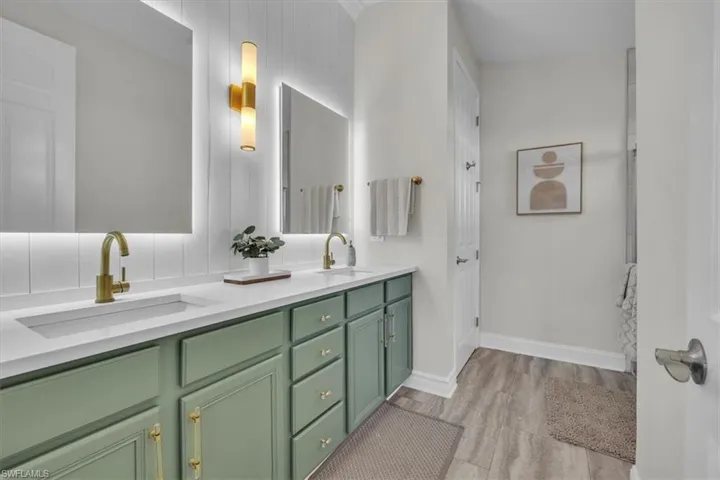 Bathroom featuring double vanity and light wood-style floors