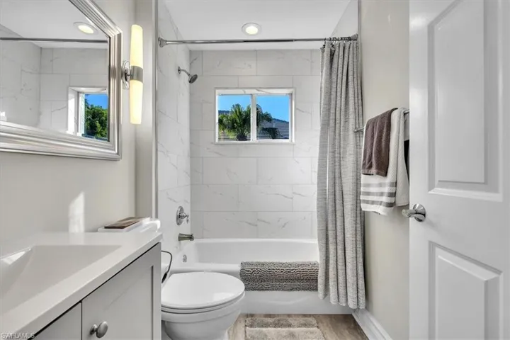 Bathroom with shower / bath combination with curtain and vanity
