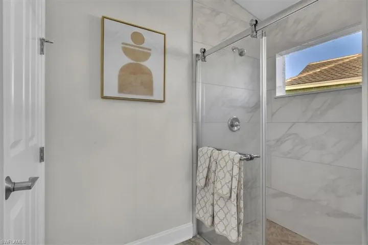 Bathroom featuring a stall shower and baseboards