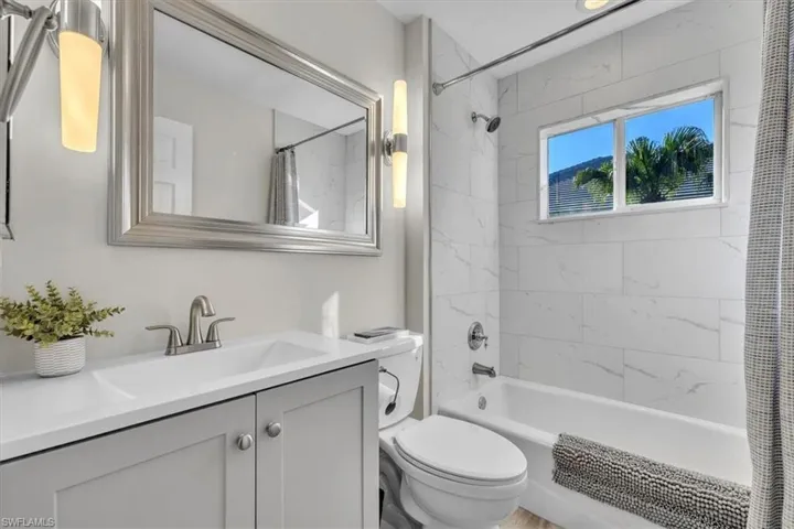 Bathroom with shower / bath combination with curtain and vanity