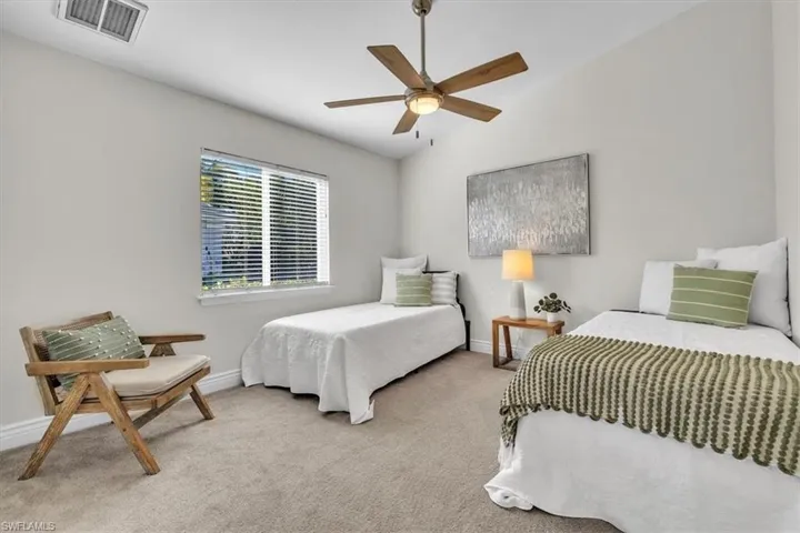 Bedroom featuring light colored carpet, a ceiling fan, and vaulted ceiling