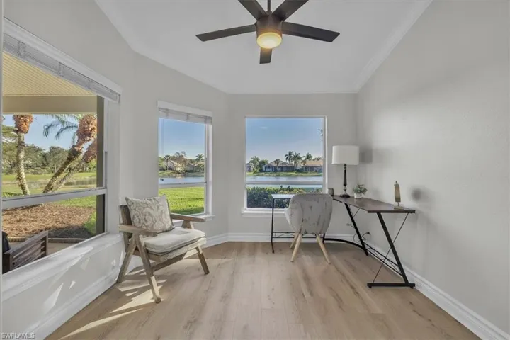 Office featuring light wood-type flooring, ornamental molding, ceiling fan, and a water view
