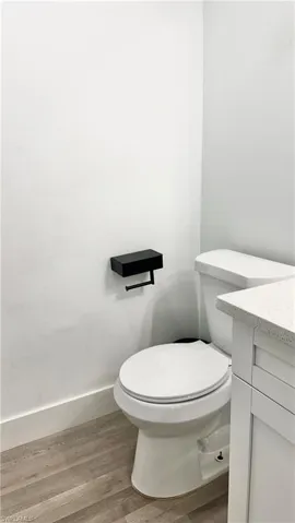 Half bathroom with wood finished floors and vanity