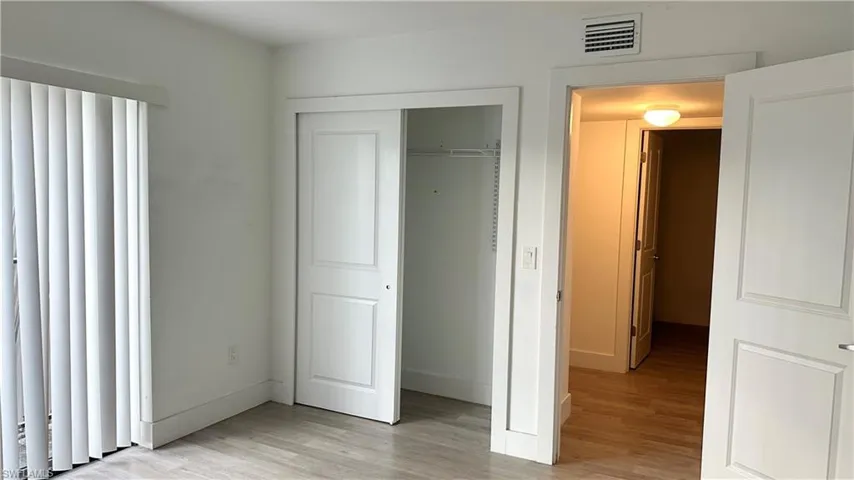 Unfurnished bedroom featuring light wood finished floors and a closet