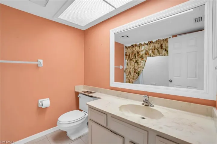 Bathroom with vanity, toilet, and tile patterned floors