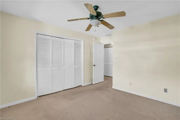 Unfurnished bedroom featuring a closet, ceiling fan, and light carpet