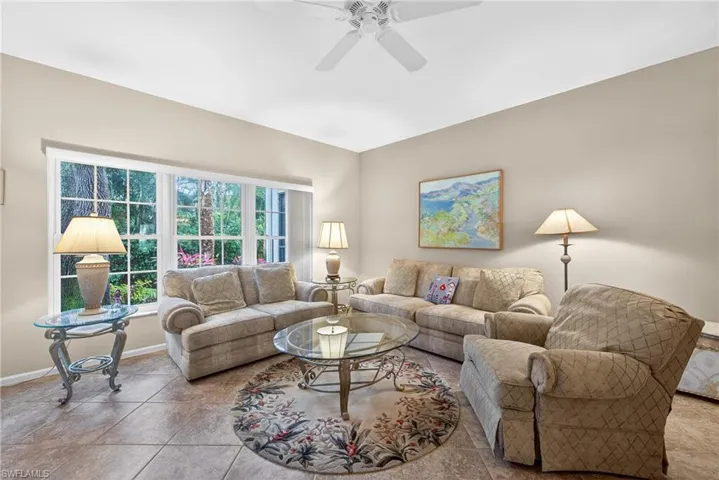 Living area with ceiling fan and baseboards