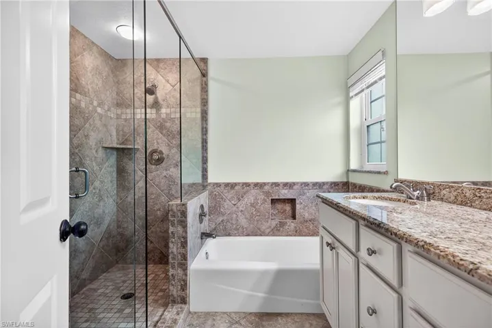 Bathroom with vanity, a bath, and a shower stall