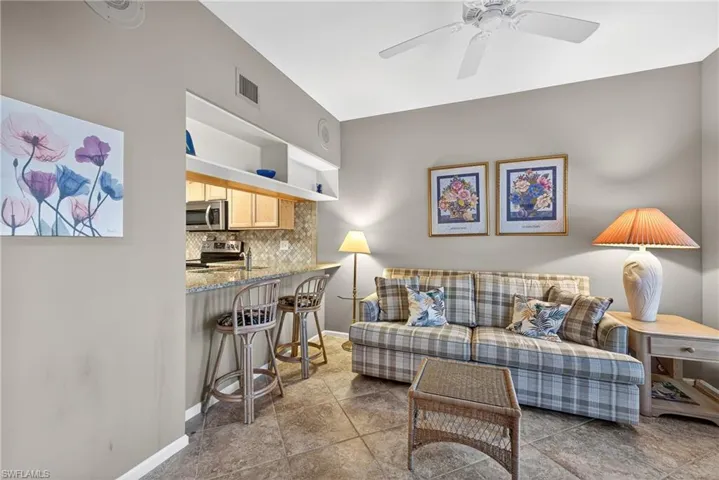 Living area with ceiling fan and baseboards