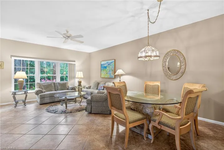 Tiled dining room featuring a ceiling fan and hanging lights