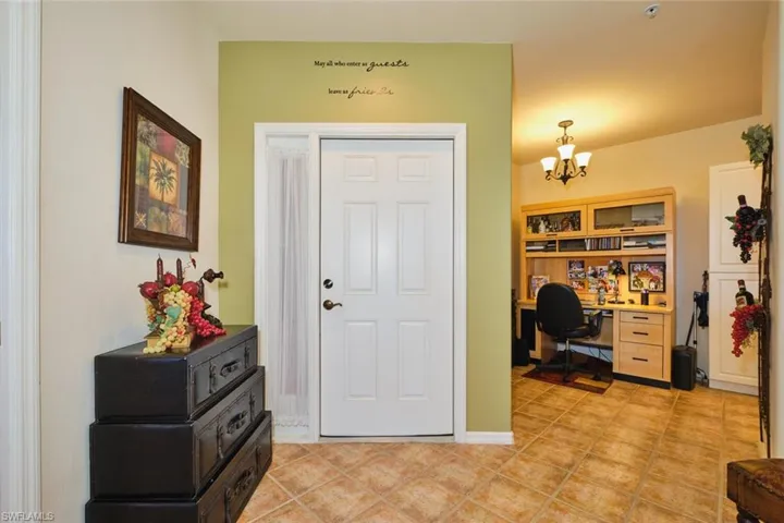 Entryway with hanging lights and light tile patterned floors