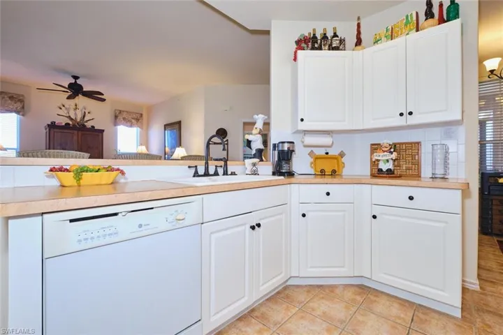 Kitchen with dishwasher, light countertops, and white cabinetry