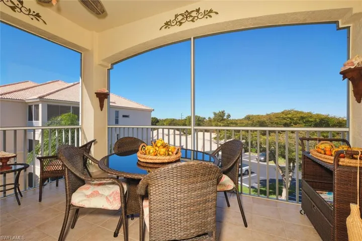 Balcony featuring a sunroom and outdoor dining area