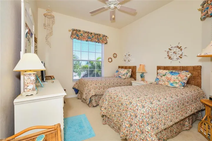 Carpeted bedroom featuring a ceiling fan and baseboards