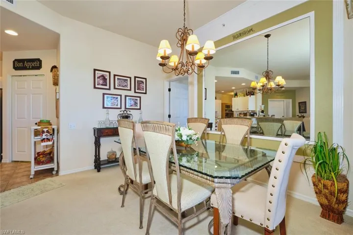 Dining area with hanging lights and light carpet