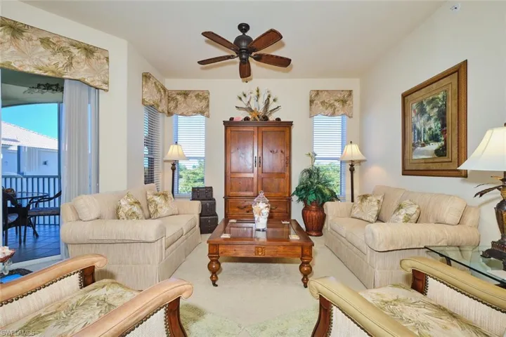 Living area featuring ceiling fan, plenty of natural light, and carpet