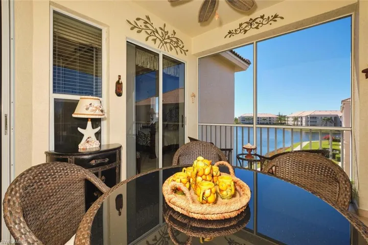 Balcony with ceiling fan, a water view, and a sunroom
