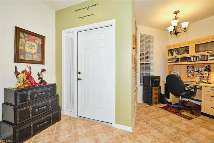 Foyer entrance with light tile patterned flooring and suspended lighting