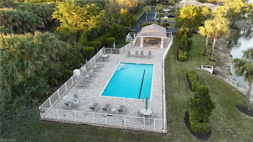 View of swimming pool with a bar, a patio area, and a lawn