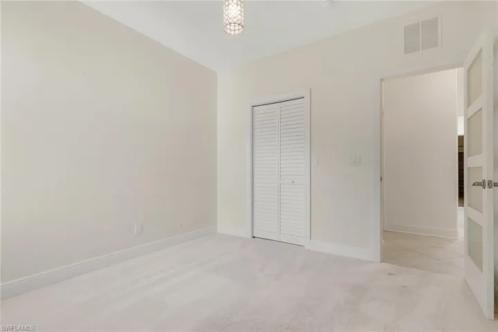 Unfurnished bedroom with light colored carpet and a closet
