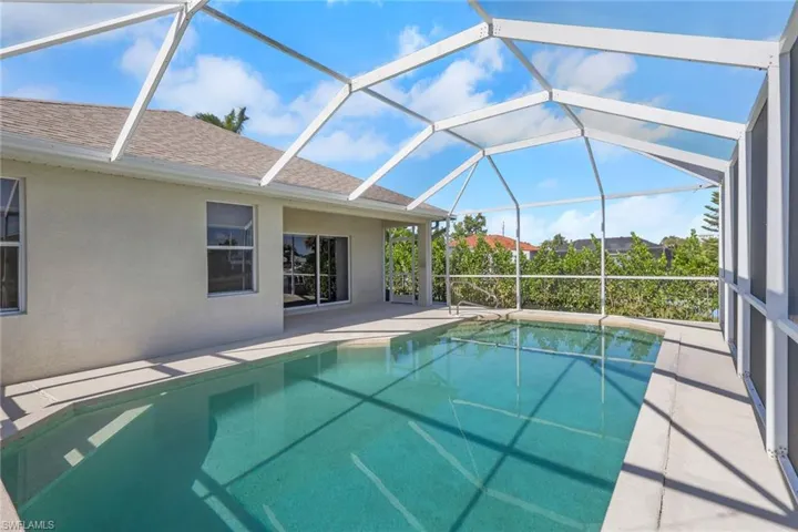 Swimming pool with a sunroom, a patio, and glass enclosure