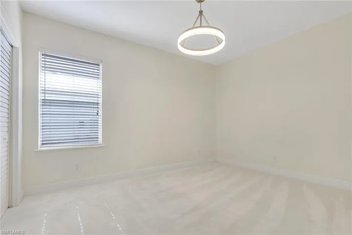 Spare room featuring light carpet and baseboards
