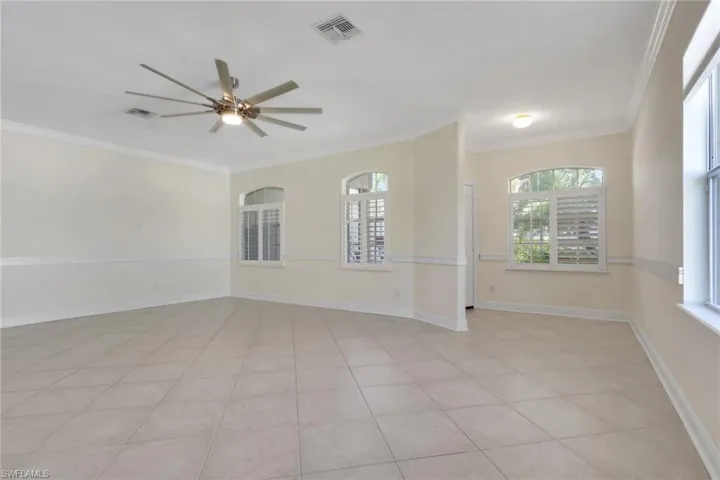 Spare room with ornamental molding, ceiling fan, plenty of natural light, and light tile patterned flooring