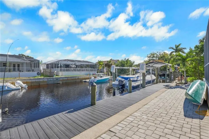 Dock with a water view, boat lift, and a residential view