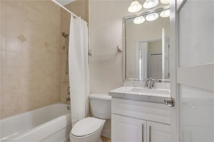 Bathroom featuring shower / tub combo with curtain and vanity