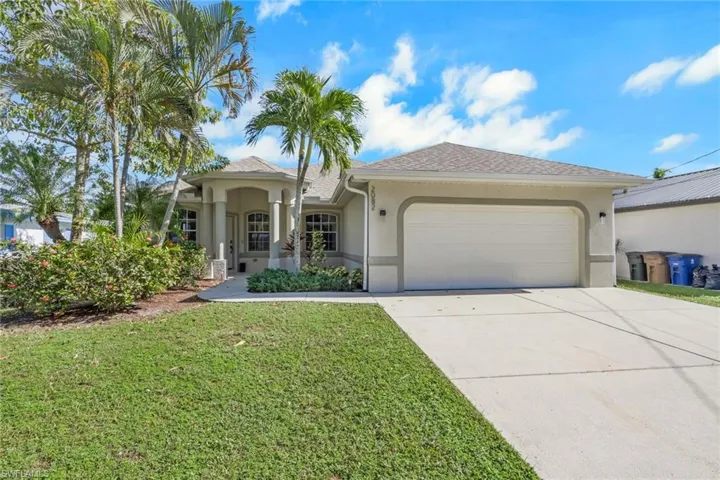 View of front of home with stucco siding, concrete driveway, an attached garage, and a front lawn